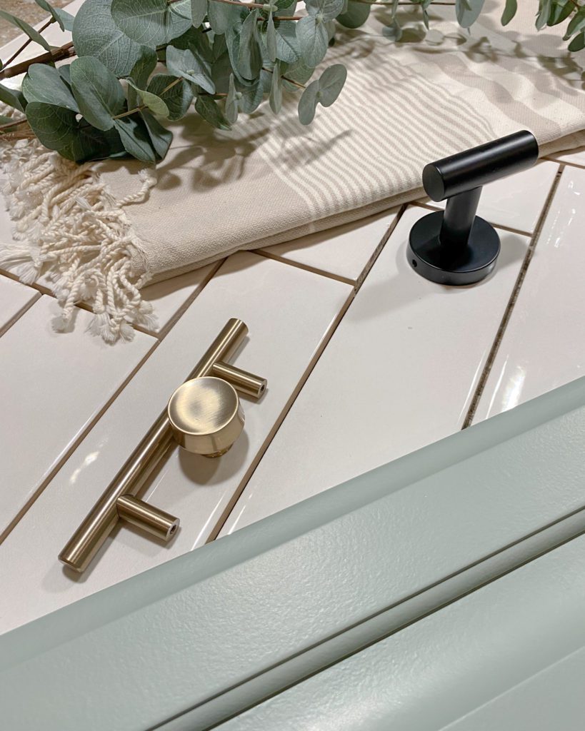 Bathroom mood board including white tile, brushed gold finishes and sage green cabinets
