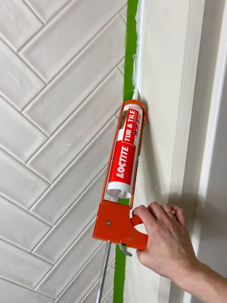 applying caulk to outside of tiles