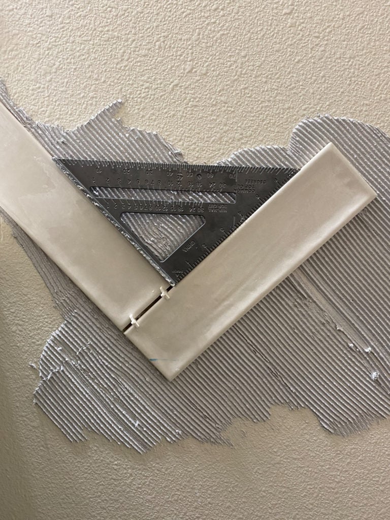 Using a speed square to help get a perfect herringbone pattern with tile