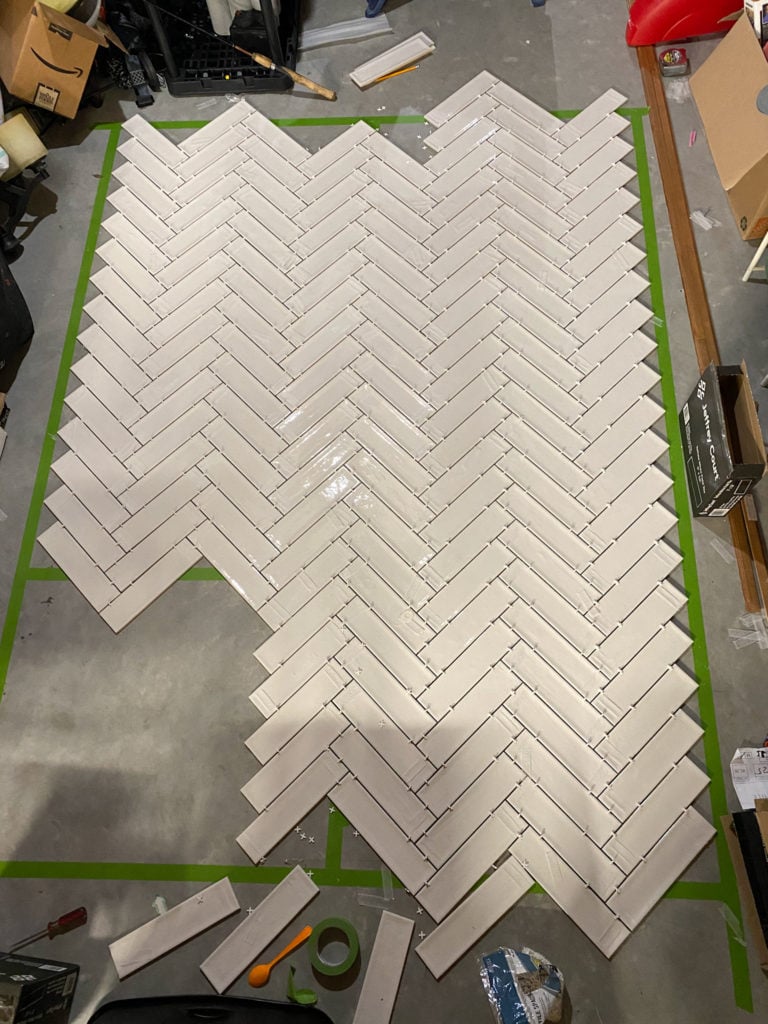 Laying out herringbone pattern on floor before tiling