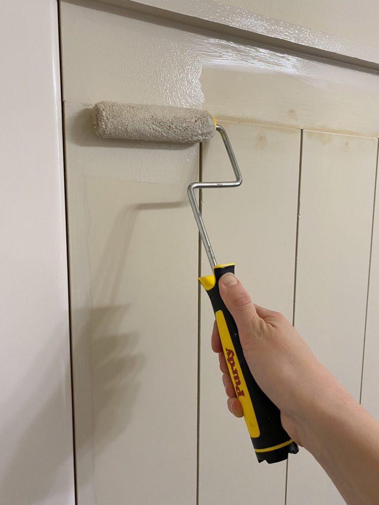 Applying paint to shiplap wall using Purdy mini roller